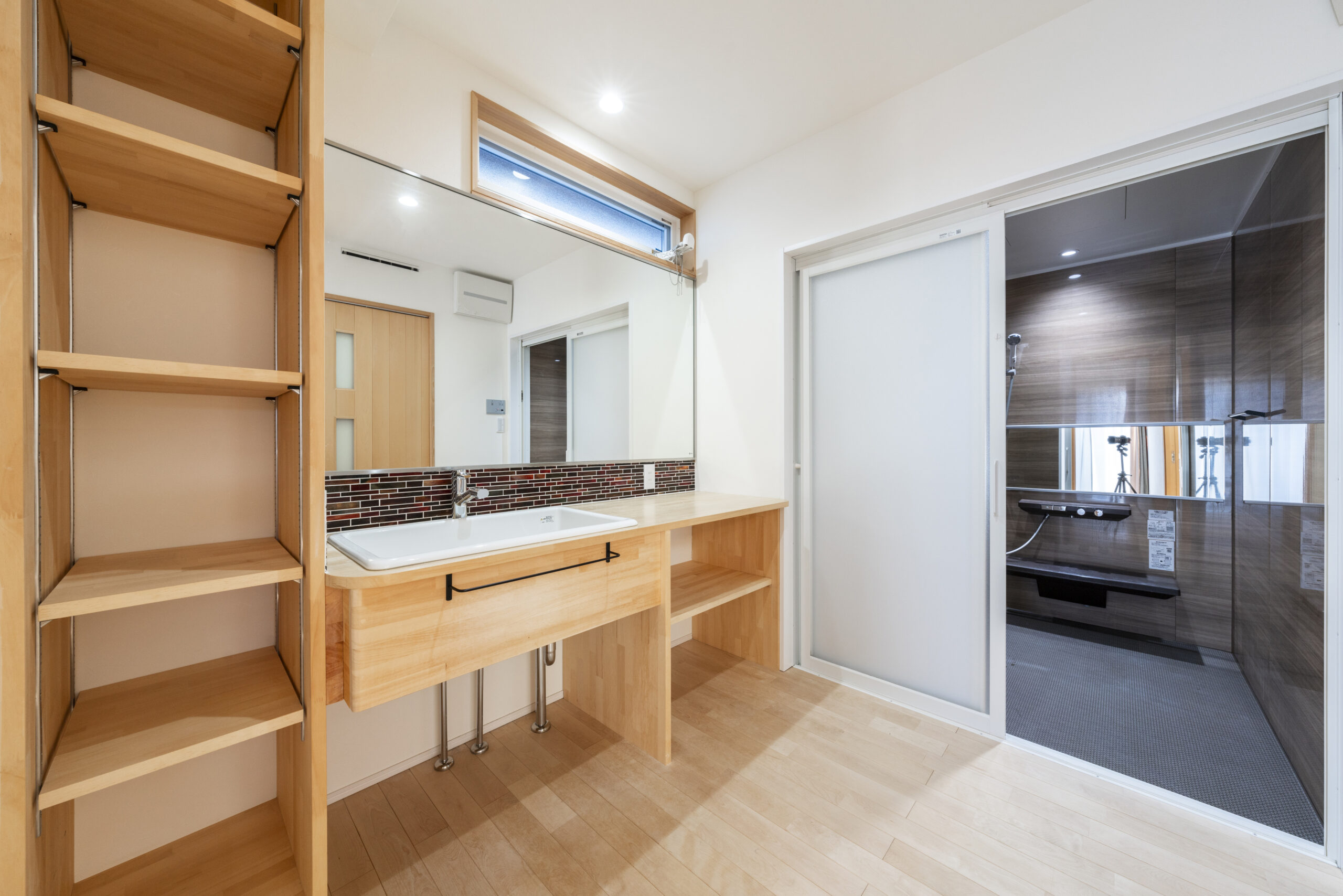 白い塗り壁と木目が美しい三角屋根の家